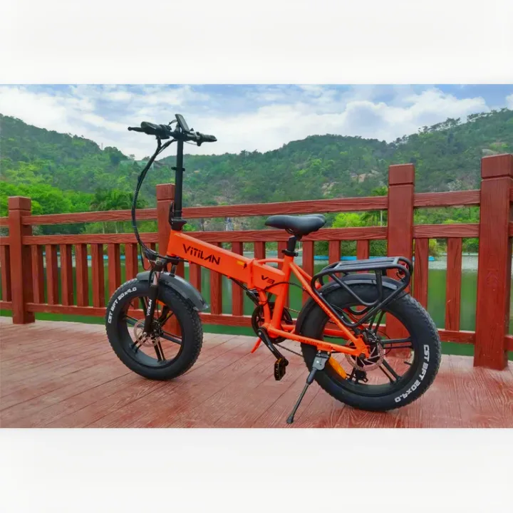An orange Vitilan folding e-bike on a deck by a lake. Great portable option for RV rental trips and outdoor adventure.. Thor Four Winds 2015