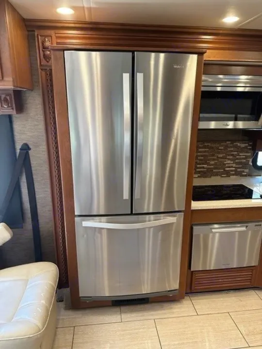 Modern stainless steel French door fridge, microwave, and dishwasher in this RV rental kitchen. Perfect for your next trip.. Holiday Rambler Endeavor 2017