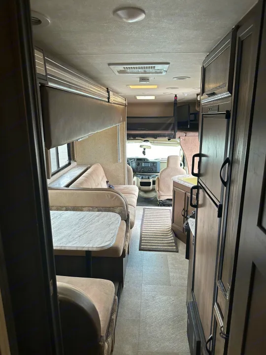 Spacious rv rental interior featuring a dinette, full kitchen, and driver's cabin. Perfect for road trips.. Forest River Coachmen Freelander 2018