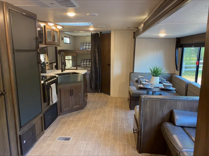 Modern RV rental interior showing a full kitchen, bunk beds, and a comfortable dining area. Perfect for family trips!. Forest River Cherokee Grey Wolf 2021