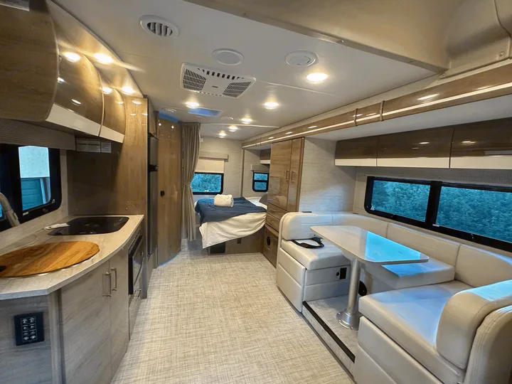 Spacious RV rental interior featuring a modern kitchen, cozy bedroom, and comfortable dining area.. Entegra Coach Qwest 2023
