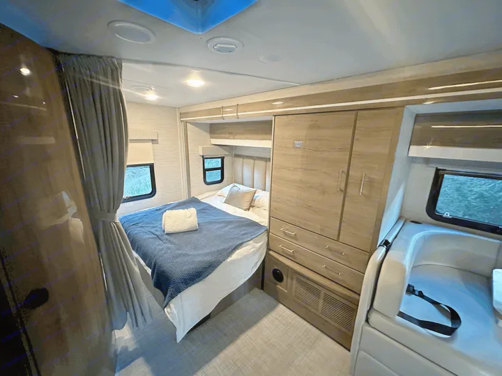 Experience comfort in this RV rental's inviting bedroom, complete with a cozy bed, ample storage, and scenic views.. Entegra Coach Qwest 2023