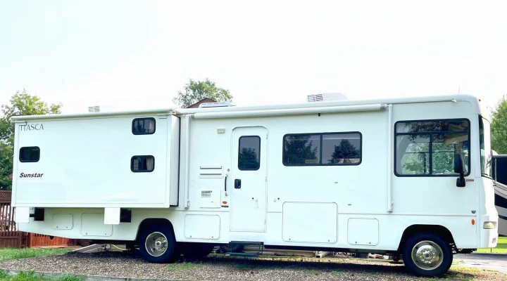 Side view of a large, white Itasca Sunstar RV rental, a spacious motorhome perfect for travel and camping.. Itasca Sunstar 2008