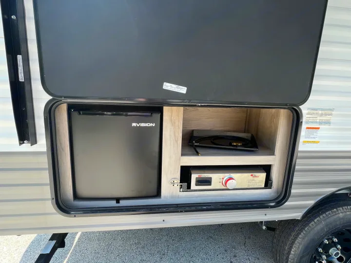 Explore this RV rental's outdoor kitchen, complete with a mini-fridge and griddle for convenient campsite cooking.. KZ Sportsmen 191BHK 2022