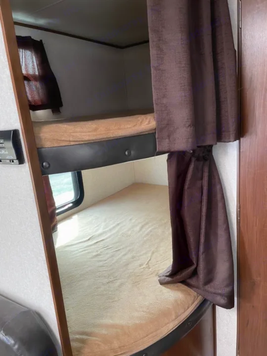 Cozy bunk beds in an RV rental, perfect for family travel. Features privacy curtains & windows for comfort.. Jayco Jay Flight 2017