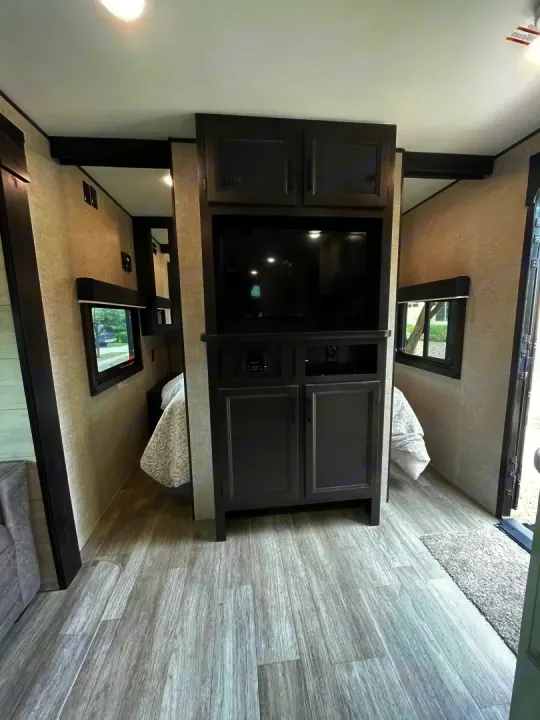 RV rental: Modern interior featuring entertainment center, bed area, and light wood flooring.. Jayco Jay Flight Baja Edition 2023