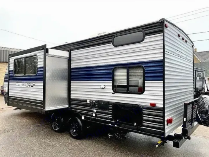 A sleek silver and blue Grey Wolf travel trailer with an extended slide-out, perfect for an rv rental adventure.. Forest River Cherokee Grey Wolf 2022
