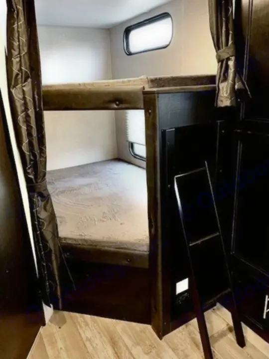 Cozy RV rental bunk beds offer comfortable sleeping. Features top & bottom bunks, windows with blinds, and a ladder.. Forest River Cherokee Grey Wolf 2022