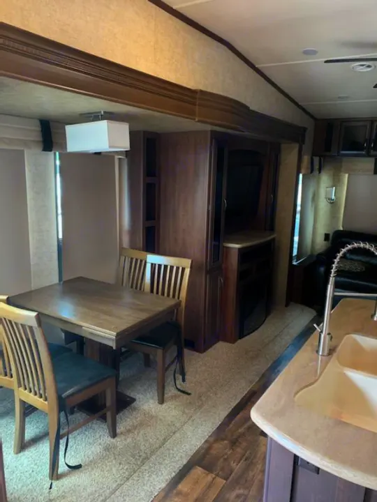 Comfortable RV rental interior featuring a dining table, kitchen, and living area for your next adventure.. Forest River Sandpiper 2018