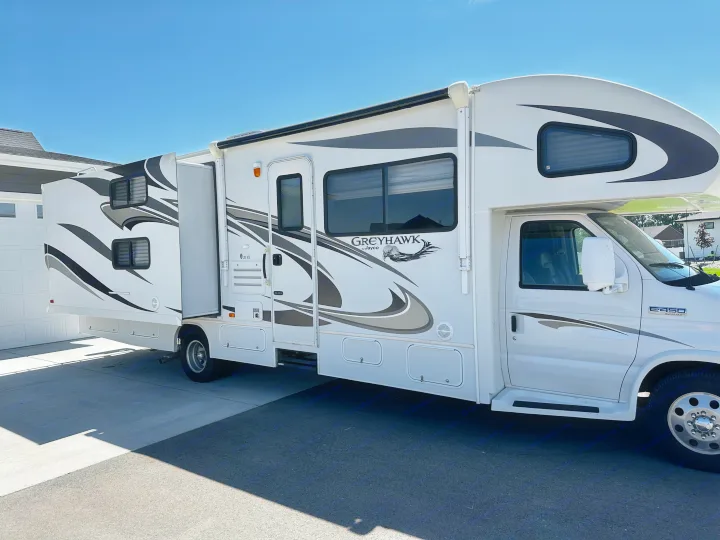 White Class C Jayco Greyhawk RV rental with slide-out extended, parked on a sunny day.. Jayco Greyhawk 2012
