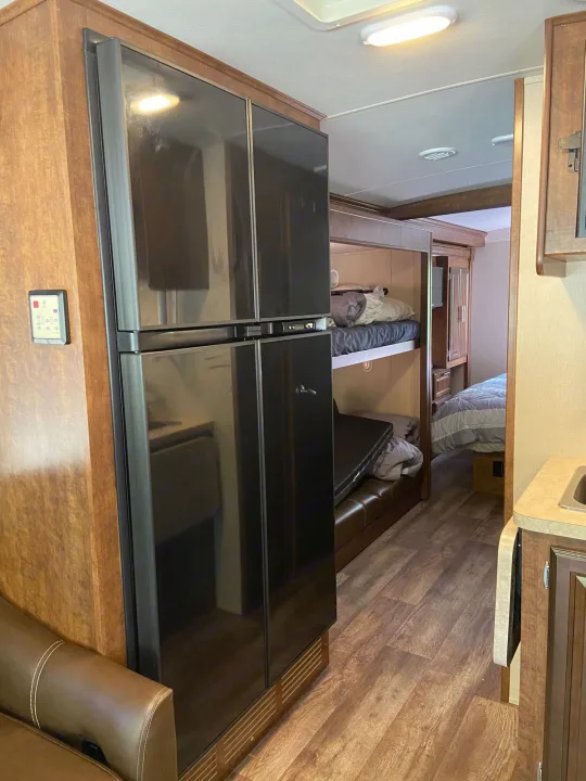 Spacious RV rental interior with full-size fridge, bunk beds, and private bedroom, ideal for family travel.. Forest River Fr3 2017