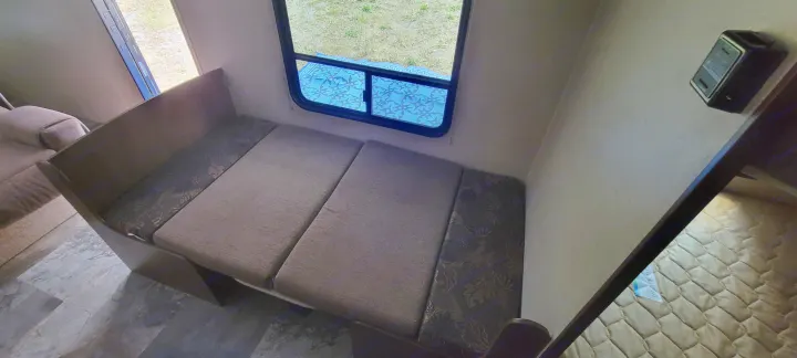 RV rental interior: Dinette with bench seating & window view, plus a glimpse of the bed, perfect for compact mobile living.. Jayco Jay Flight SLX 2015