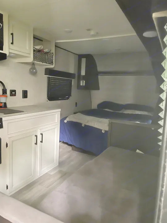 Cozy RV rental interior featuring a compact kitchen, comfortable bed, and versatile living space.. Jayco Jay Flight SLX 2022
