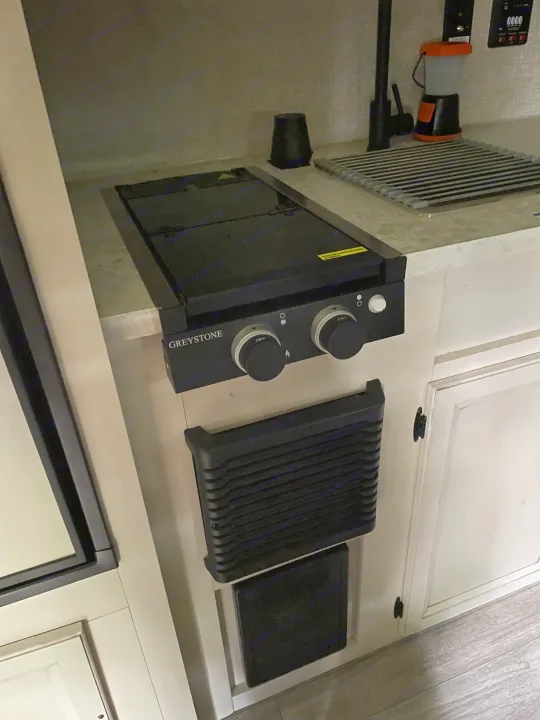 Inside an RV rental: a compact kitchen features a Greystone cooktop, modern faucet, and practical drying rack on the counter.. Jayco Jay Flight SLX 2022