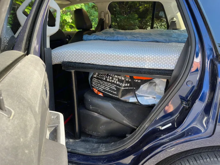 RV rental-style car camping setup: a built-in bed with bedding & storage for gear inside a car.. Ford Edge 2011