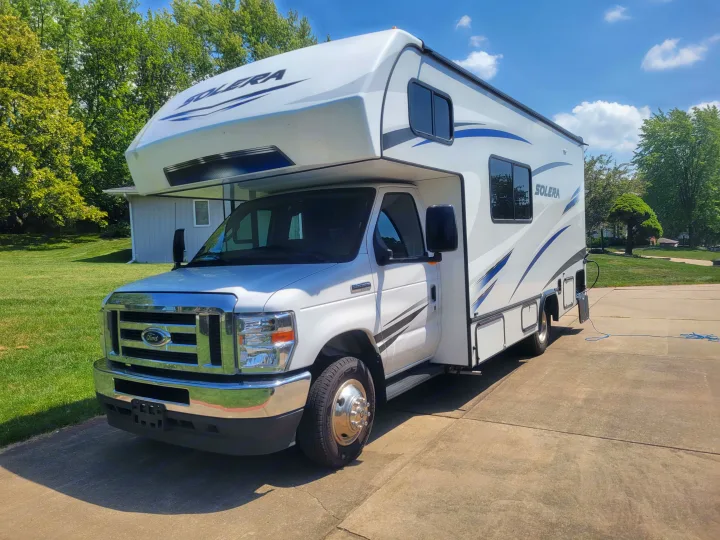 White Solera Class C RV rental, a motorhome parked on a sunny driveway, perfect for camping trips.. Solera Solera Motorhome 2022