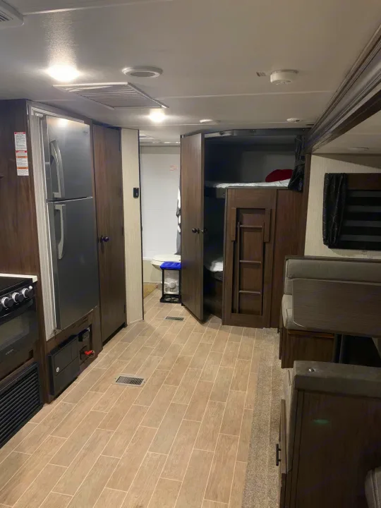 RV rental interior: kitchen, bunk beds, dinette. A functional, compact space ready for travel.. Forest River Cherokee Grey Wolf 2020
