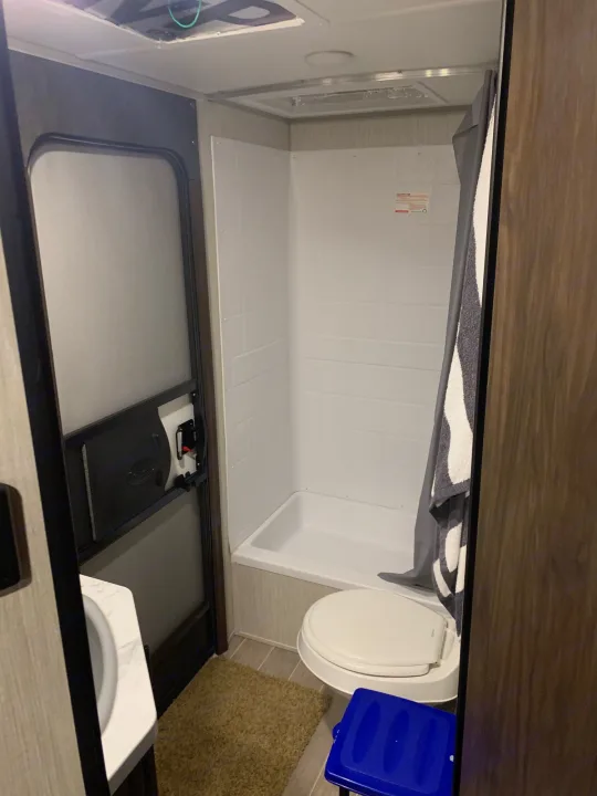 RV rental bathroom: compact shower, toilet, sink, and screen door. Everything needed for travel comfort.. Forest River Cherokee Grey Wolf 2020