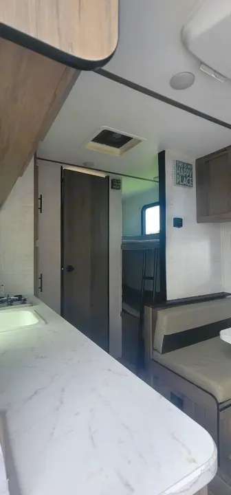 Empty shot of the sink towards the bunks and bathroom. Gulf Stream Enlighten 2021
