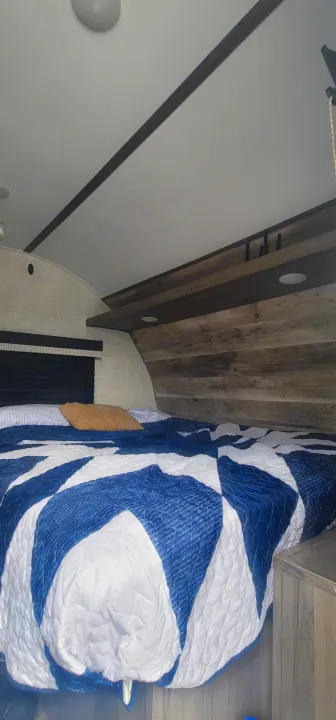 Queen bed with overhead and under storage. Bed lifts up for easy storage. Side nightstand and clothing cabinet with wall mounted TV. Gulf Stream Enlighten 2021