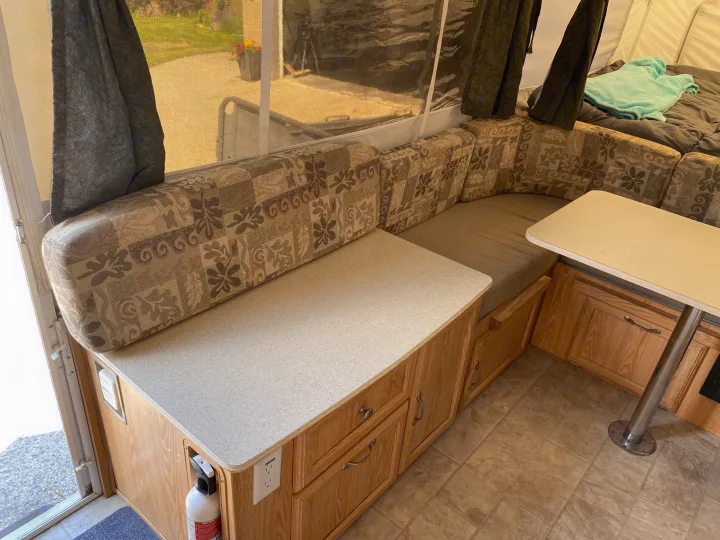 RV rental interior featuring a cozy dinette, functional counter space, bed, and storage, ready for adventure.. Palomino Yearling 2012
