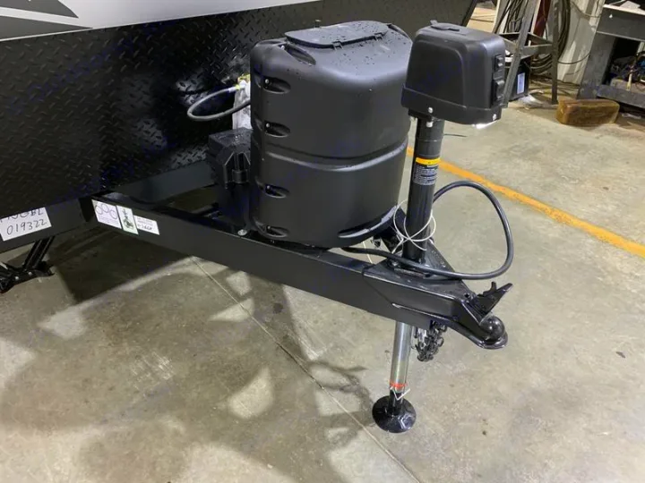 RV rental: Trailer front featuring black electric tongue jack, LP gas tank cover, and hitch assembly.. Forest River Cherokee Wolf Pup Black Label 2021