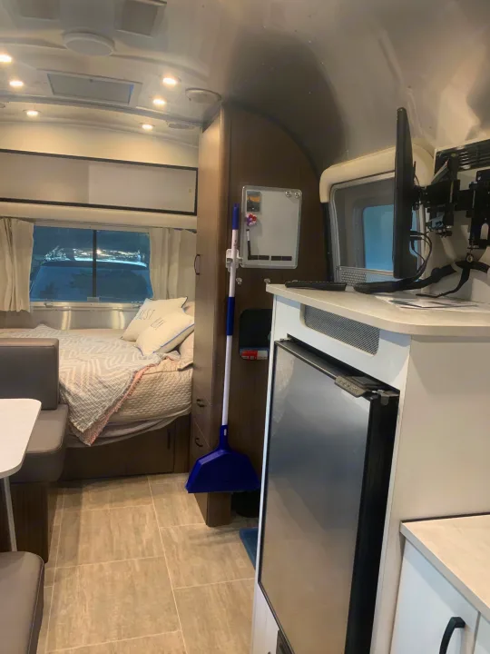 RV rental interior: A cozy bed area, dining space, and compact kitchenette inside a modern travel trailer.. Airstream Caraval 2021