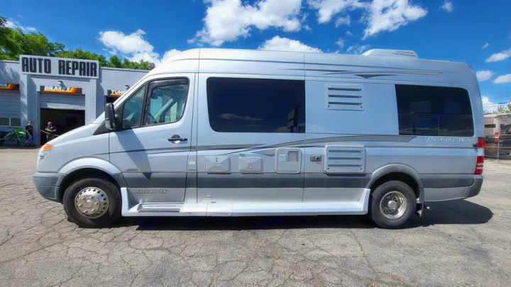 This silver Pleasure-Way Plateau-TS camper van, ideal for RV rental, is parked at an auto repair shop under a blue sky.. Mercedes AS NEW SPRINTER 4 BERTH DISCOVERY AUTO TURBO DIESEL 2013