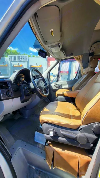 Spacious RV rental cockpit with tan captain's seats, Mercedes steering wheel, and clear dashboard. Ready for adventure!. Mercedes AS NEW SPRINTER 4 BERTH DISCOVERY AUTO TURBO DIESEL 2013