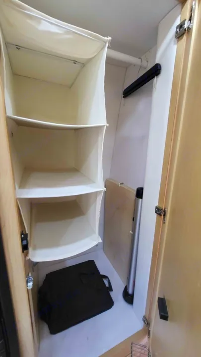 Compact RV rental closet with hanging fabric shelves, clothes rod, and floor storage for essentials.. Mercedes AS NEW SPRINTER 4 BERTH DISCOVERY AUTO TURBO DIESEL 2013