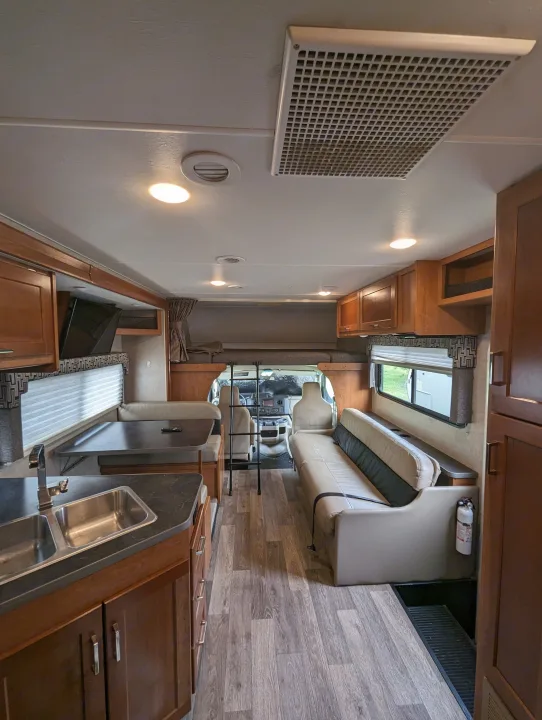 RV rental interior: A bright, clean space with kitchen, dinette, sofa, and over-cab bunk area.. Winnebago Spirit 2019