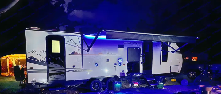 Experience night camping with this illuminated RV rental! A Grey Wolf travel trailer with mountain decals, lit by blue LEDs.. Forest River Cherokee Grey Wolf Black Label 2021