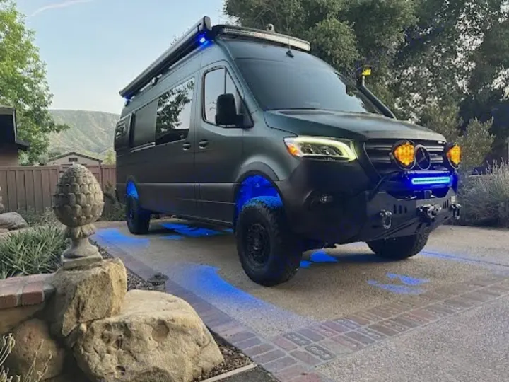 This rugged, dark green Mercedes Sprinter rv rental is an adventure-ready van, boasting off-road lights and striking blue underglow.. Mercedes-Benz Sprinter 2020