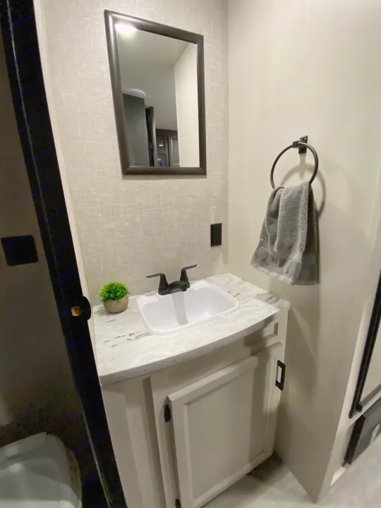 Clean and modern RV rental bathroom with sink, mirror, and towel. Perfect for your next adventure.. Jayco Jay Flight 2023