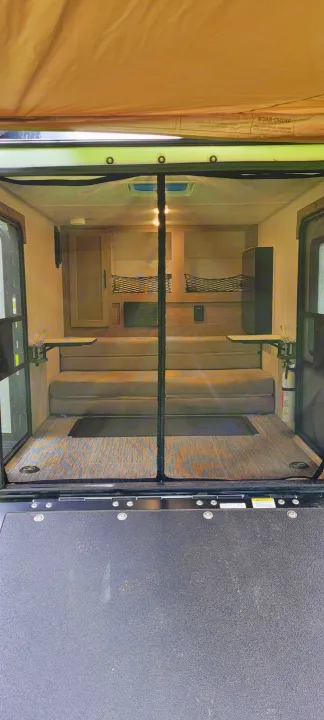 Inside an RV rental toy hauler: versatile seating, fold-down tables, screen entrance, and durable flooring.. Forest River NoBo 10.6 2022