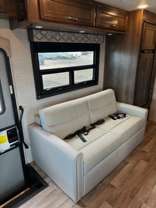RV rental: Spacious interior with light sofa, safety belts, window, wood-look floor, & overhead storage.. Jayco Redhawk 2021