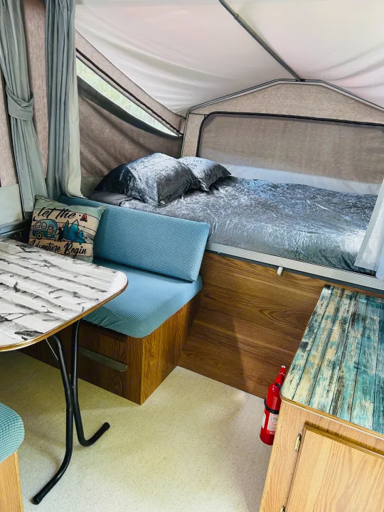 Explore this cozy RV rental's interior: comfy bed, dining nook, and "adventure" pillow. Ideal for camping trips!. Cobra Flagstaff 1995