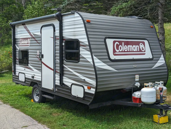 This gray Coleman travel trailer, complete with propane tanks and awning, is perfect for an RV rental getaway.. Dutchmen Coleman Lantern LT 2017