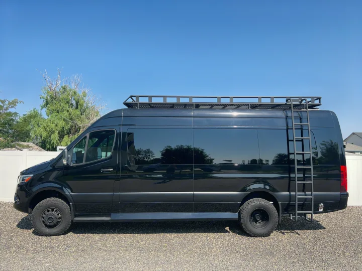 Black Mercedes-Benz Sprinter camper van with a roof rack and ladder, ideal for your next rv rental adventure.. Midwest Automotive Designs Ultimate Coach 2021