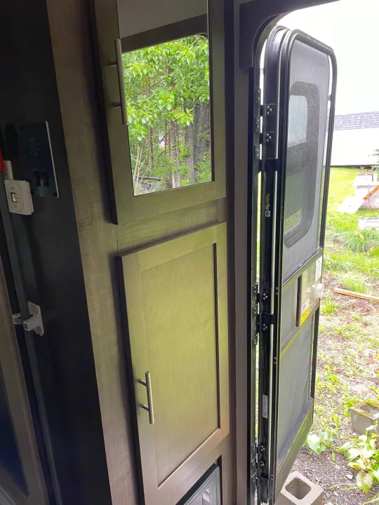 RV rental: Interior view with open screen door to outdoor greenery. Visible cabinets, controls, and door hinges.. R-Pod R-Pod Trailer 2017