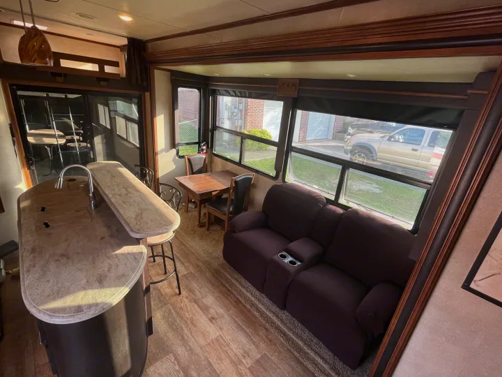 Explore this inviting RV rental: a spacious living area featuring a kitchen island, dining nook, and comfortable reclining sofa.. Forest River XLR Thunderbolt Toy Hauler 2015