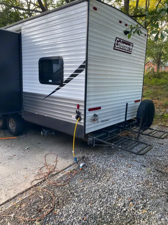 This Coleman **rv rental** travel trailer, showcasing its rear cargo carrier & utilities connected. Ideal for your next outdoor adventure.. Coleman Lantern 2021