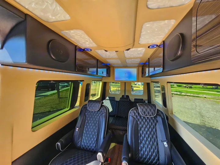 Inside a premium RV rental: comfortable quilted leather seating, overhead storage, accent lighting, and a TV for travel.. Mercedes-Benz Sprinter 2017
