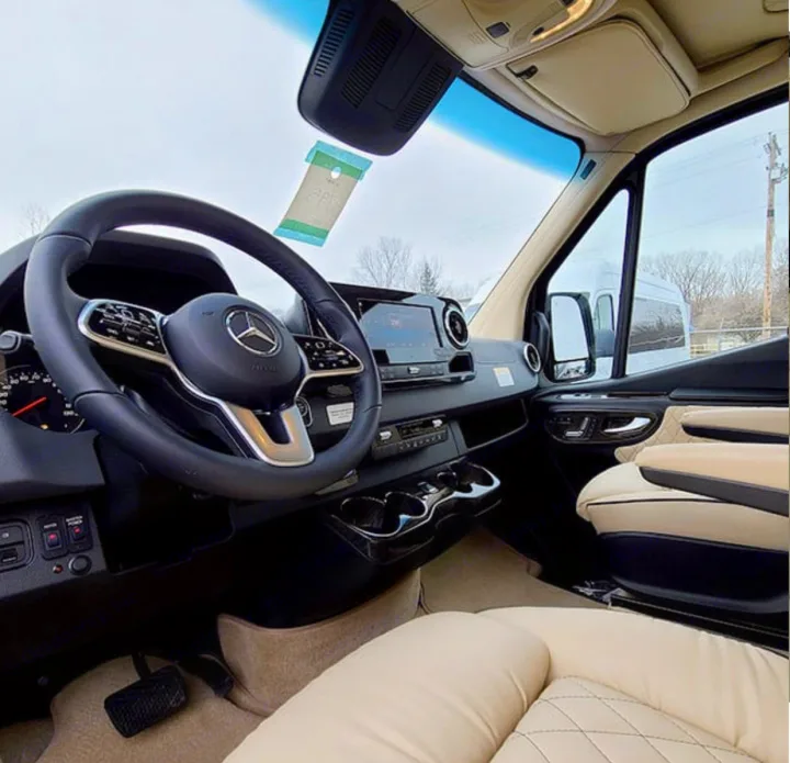 Inside a premium RV rental: View of a Mercedes-Benz cockpit with cream leather seats and a modern dashboard.. Ultimate Toys Ultimate Coach 2023