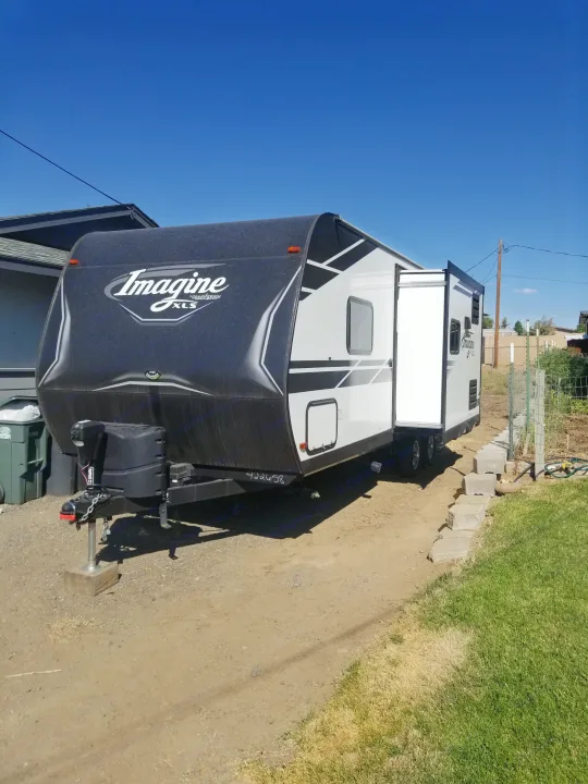 Grand Design Imagine XLS travel trailer for rv rental, parked outdoors with slide-out extended.. Grand Design Imagine XLS 2021