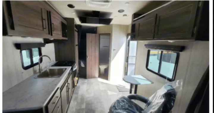 Spacious rv rental interior showcases a modern kitchen, dining area, and bathroom. Perfect for comfortable journeys.. Genesis Supreme Rv Powerlite Prime 1915 2022