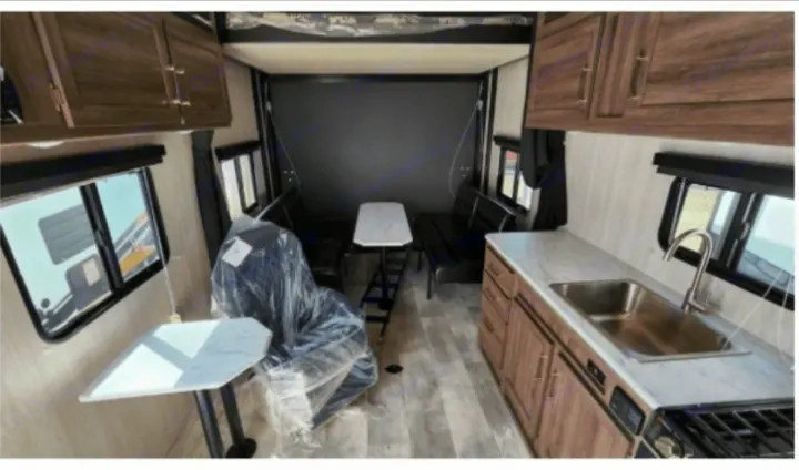Explore this RV rental's spacious interior, featuring a well-equipped kitchen, dining table, and flexible seating in the rear.. Genesis Supreme Rv Powerlite Prime 1915 2022