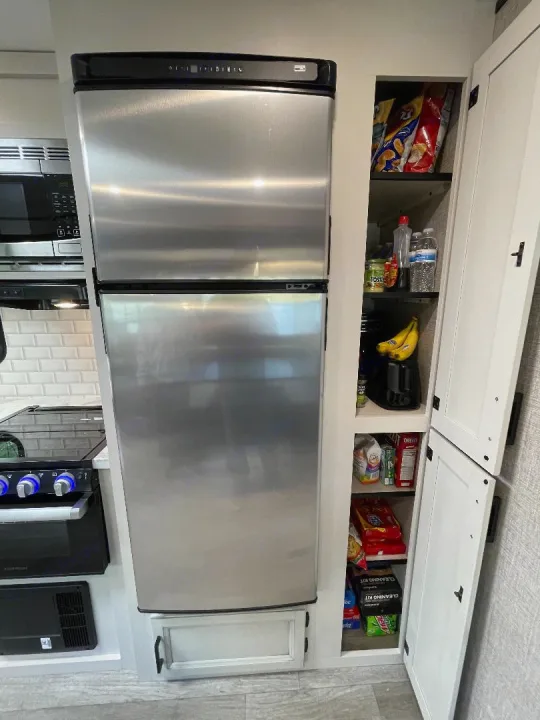 Well-equipped RV rental kitchen: stainless fridge, microwave, stovetop, and stocked pantry.. Jayco Jay Flight 2022