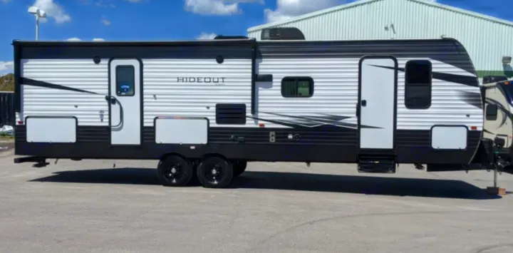 This white and black Hideout travel trailer with dual entry doors is ideal for an rv rental getaway.. Keystone RV Hideout Luxury 2021