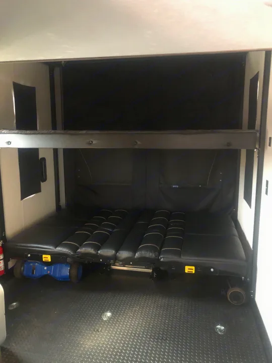 Spacious RV rental toy hauler interior: bunk beds convertible to seating/sleeping area.. Forest River Cherokee Wolf Pack Toy Hauler 2021